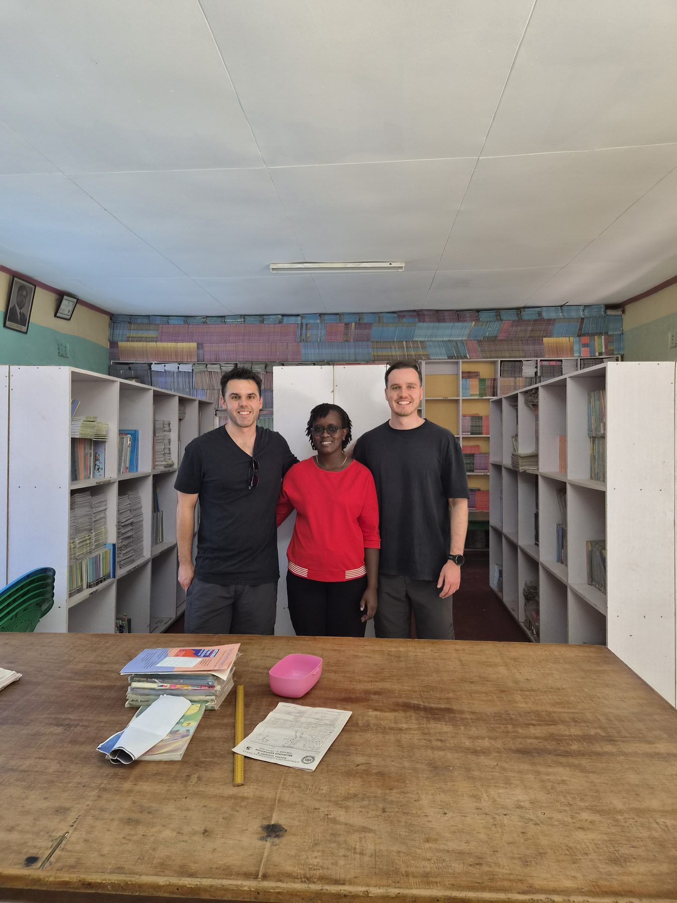 OnCourse team members and a local school leader in a library supported by OnCourse