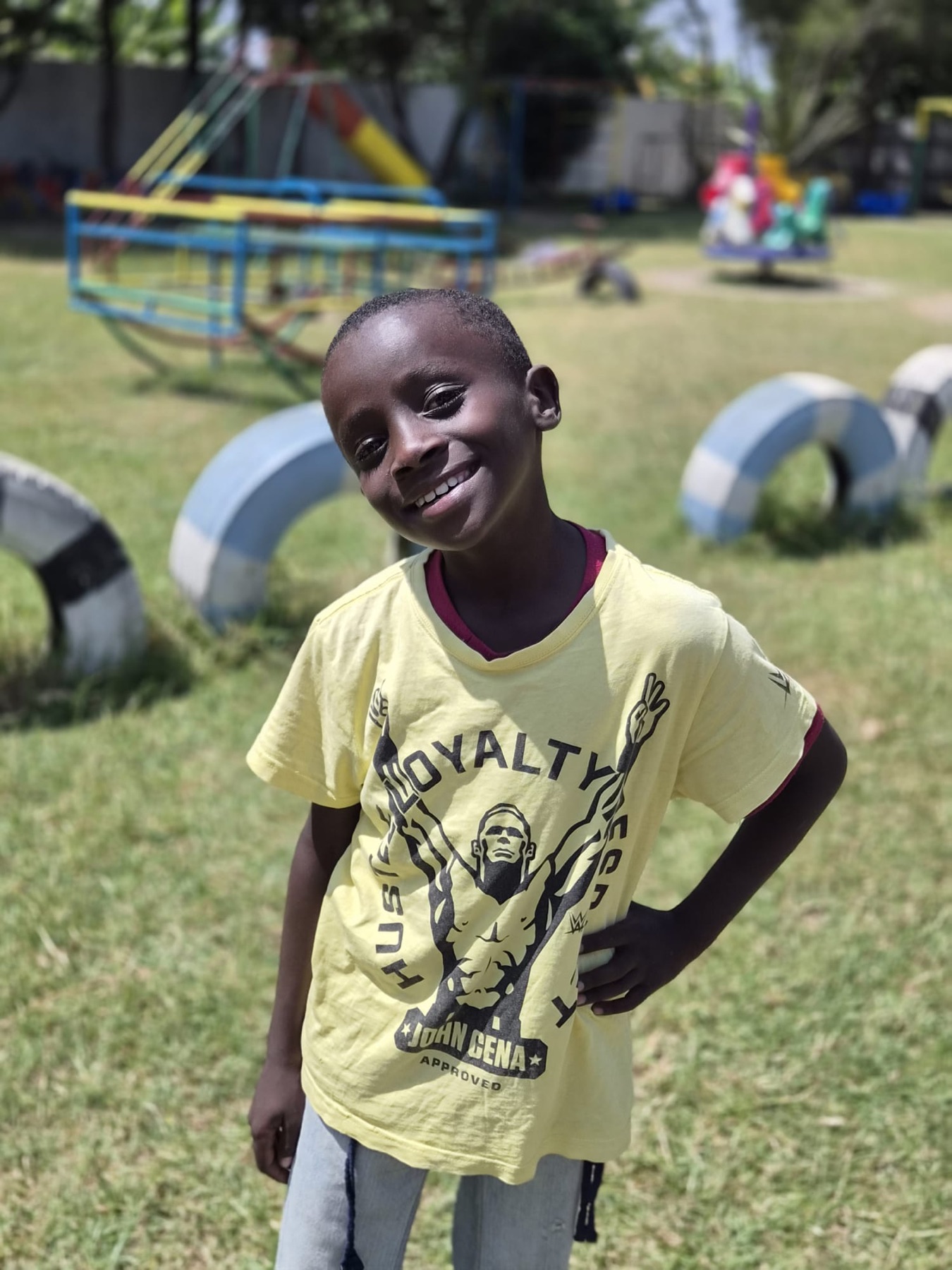A smiling OnCourse-supported child at a playground in Kenya