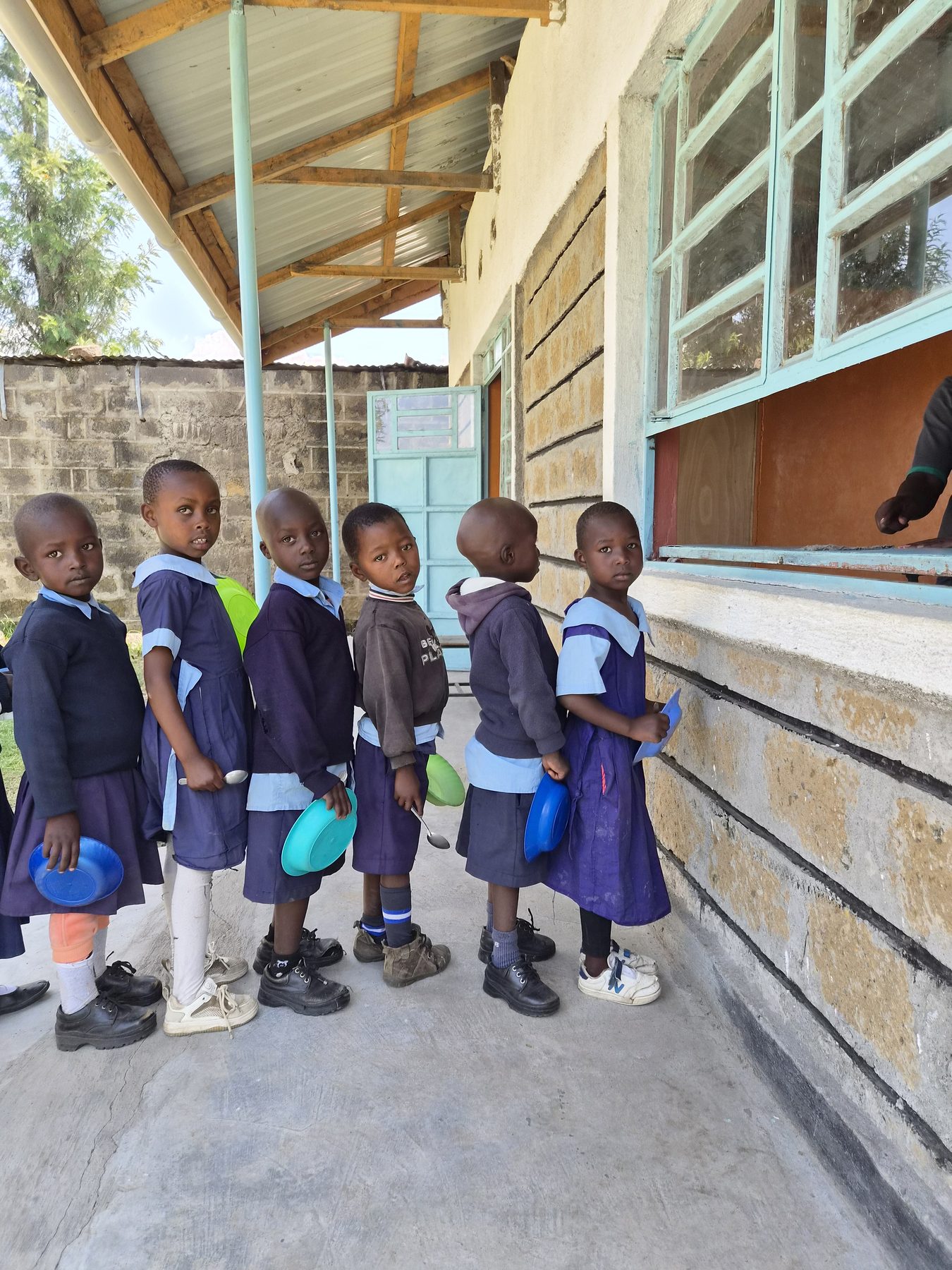 Primary school students queueing for lunch outside their classroom in Kenya